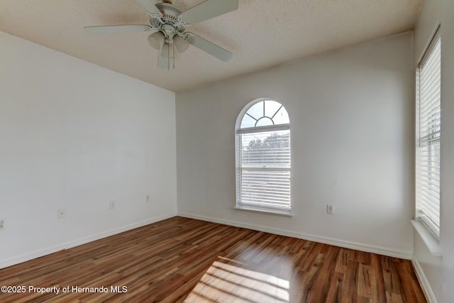 unfurnished room featuring baseboards, ceiling fan, and wood finished floors