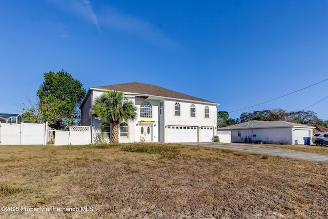 view of front of property featuring concrete driveway, stucco siding, fence, an attached garage, and a front yard