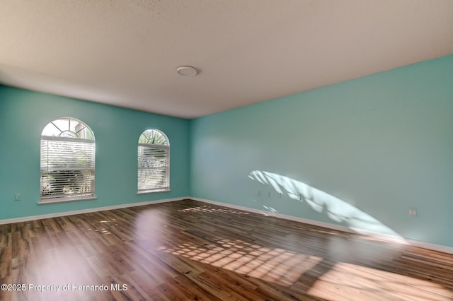 empty room featuring baseboards and wood finished floors