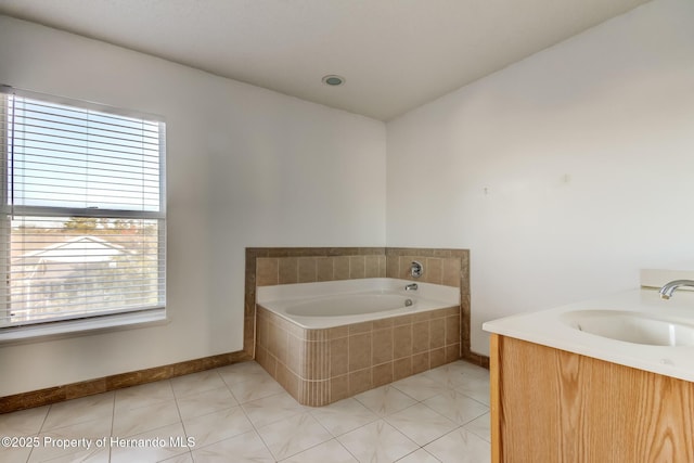bathroom with tile patterned floors, a sink, and a garden tub