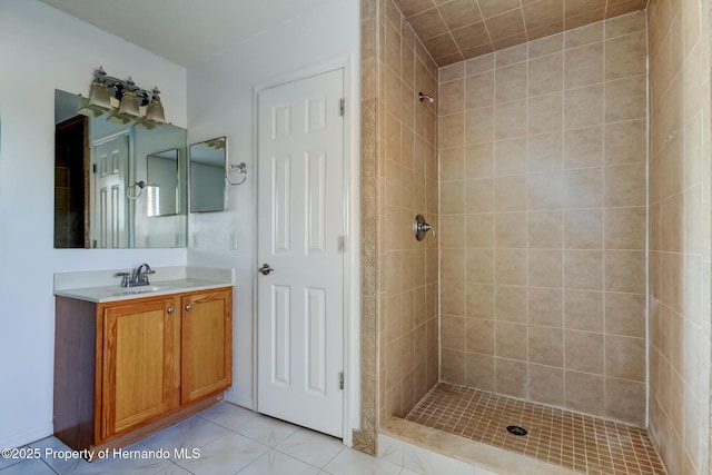 bathroom featuring tiled shower, tile patterned flooring, and vanity