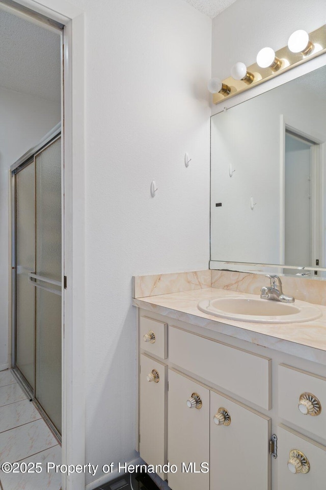 bathroom featuring vanity and a shower stall