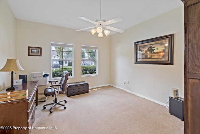 office area with baseboards, a ceiling fan, and light colored carpet