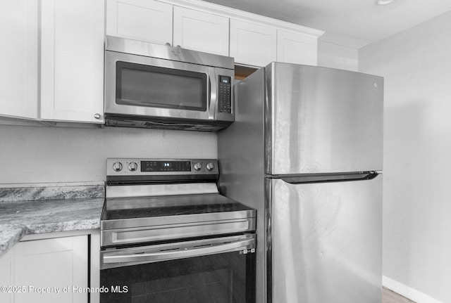 406 Zoller St, Brooksville, FL 34601 - kitchen with baseboards, white cabinets, and appliances with stainless steel finishes