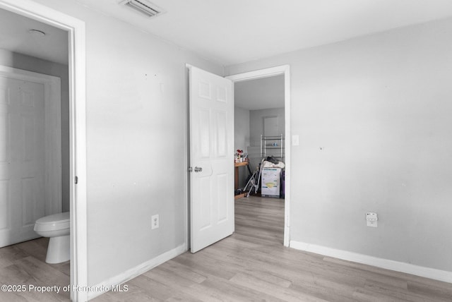 406 Zoller St, Brooksville, FL 34601 - unfurnished bedroom featuring connected bathroom, baseboards, visible vents, and light wood-type flooring
