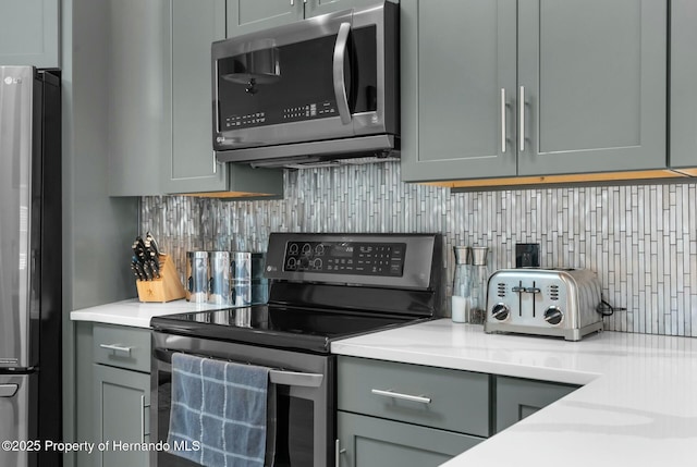 1156 Battersea Ave, Spring Hill, FL 34609 - kitchen featuring gray cabinets, light countertops, backsplash, and stainless steel appliances
