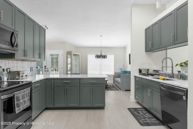 1156 Battersea Ave, Spring Hill, FL 34609 - kitchen with a notable chandelier, light countertops, a sink, appliances with stainless steel finishes, and a peninsula