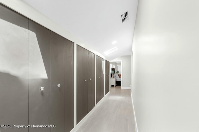 1156 Battersea Ave, Spring Hill, FL 34609 - hallway with baseboards, visible vents, light wood-type flooring, and vaulted ceiling