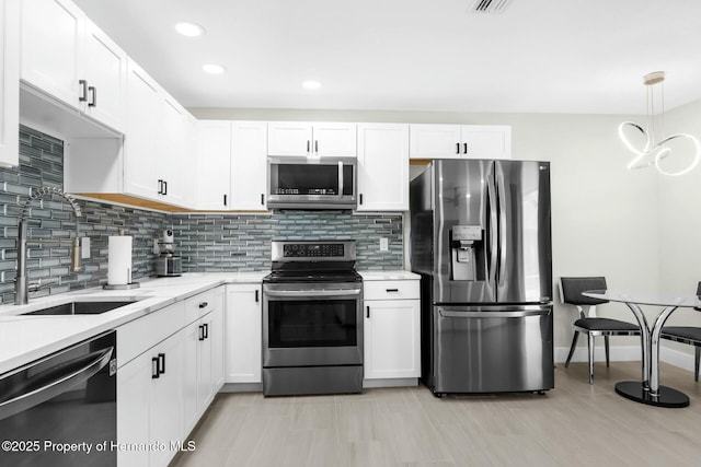 1156 Battersea Ave, Spring Hill, FL 34609 - kitchen with white cabinetry, backsplash, a sink, and stainless steel appliances