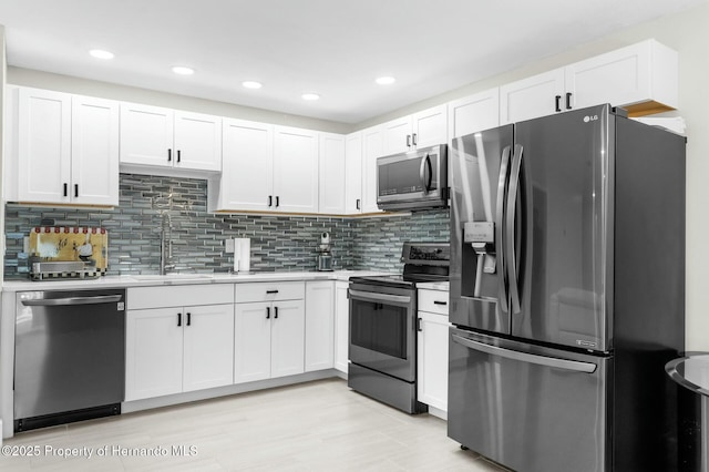1156 Battersea Ave, Spring Hill, FL 34609 - kitchen with white cabinetry, light countertops, a sink, and stainless steel appliances