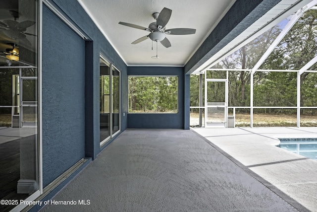 view of patio / terrace with ceiling fan, an outdoor pool, and glass enclosure