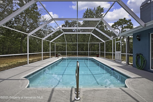 swimming pool with a patio area and glass enclosure