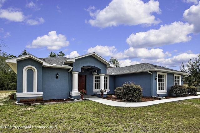 single story home featuring stucco siding and a front yard