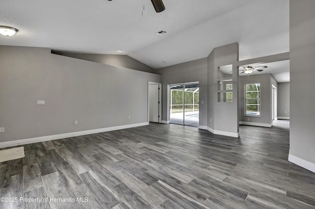 unfurnished living room featuring a ceiling fan, vaulted ceiling, baseboards, and dark wood finished floors