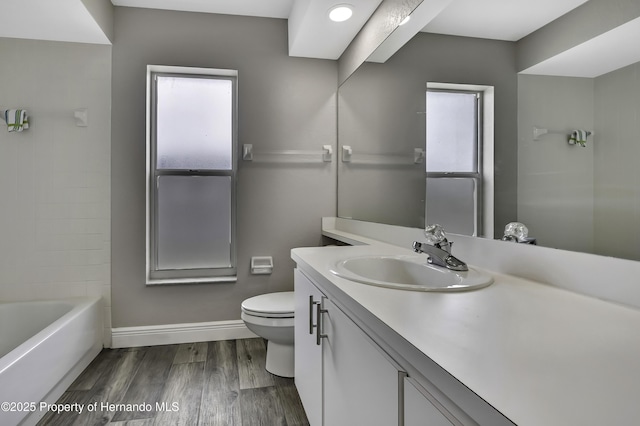 full bathroom featuring toilet, wood finished floors, vanity, and baseboards