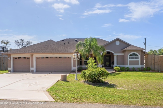 view of front of home with fence, a garage, stucco siding, a front yard, and driveway