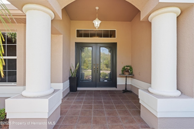 view of exterior entry featuring french doors and stucco siding