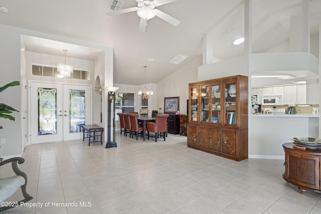 foyer featuring ceiling fan with notable chandelier, visible vents, french doors, and light tile patterned floors