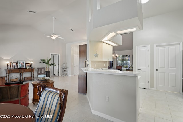 kitchen with a ceiling fan, light tile patterned floors, high vaulted ceiling, and visible vents