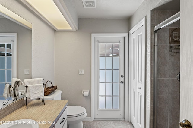 bathroom featuring visible vents, a shower stall, toilet, tile patterned floors, and vanity