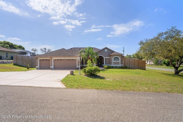 view of front of property featuring concrete driveway, a garage, fence, and a front lawn