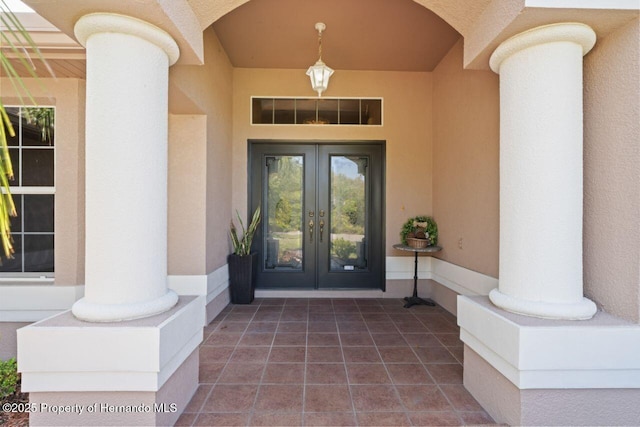 view of exterior entry featuring stucco siding and french doors