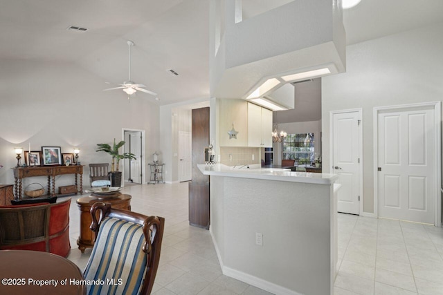 kitchen featuring high vaulted ceiling, light countertops, light tile patterned floors, visible vents, and ceiling fan
