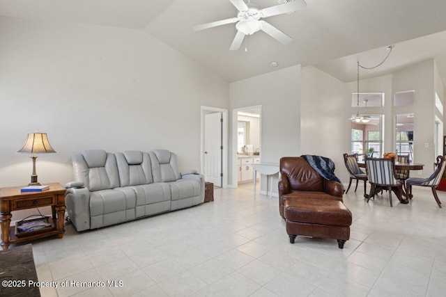 living area featuring high vaulted ceiling, light tile patterned floors, and a ceiling fan
