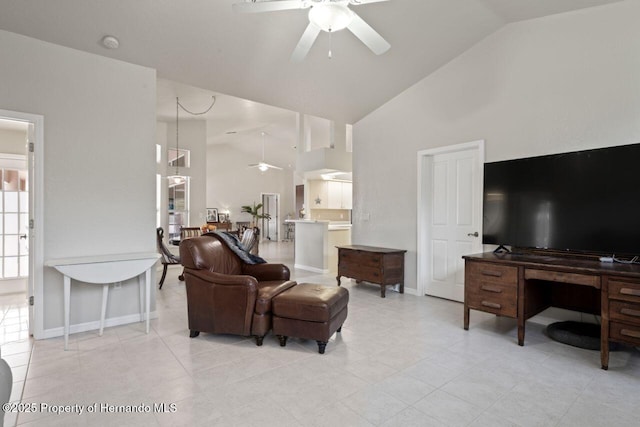 living room featuring baseboards, high vaulted ceiling, and a ceiling fan