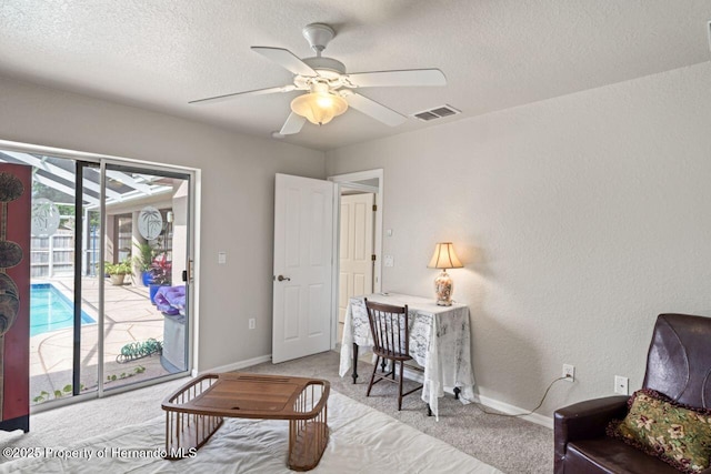 interior space featuring light colored carpet, visible vents, ceiling fan, and a textured ceiling