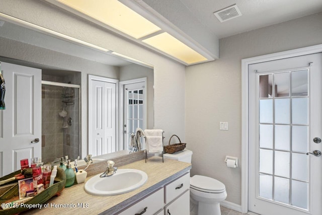 full bath featuring visible vents, baseboards, toilet, vanity, and a stall shower