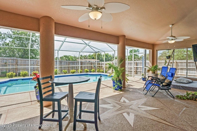 view of patio featuring a ceiling fan, a fenced backyard, a fenced in pool, and a lanai