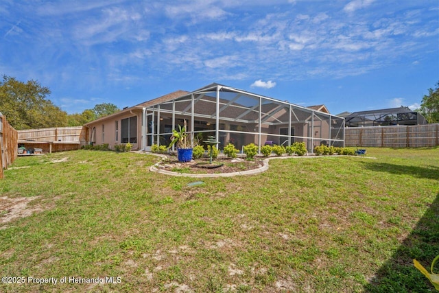 back of property featuring a fenced backyard, a lanai, and a yard