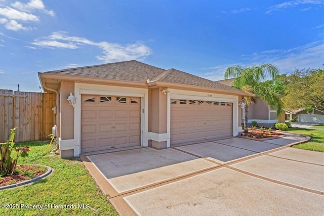 garage featuring fence and concrete driveway
