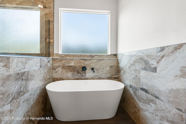 16043 Penn State Rd, Weeki Wachee, FL 34614 - full bath featuring a soaking tub, tile walls, and a wainscoted wall