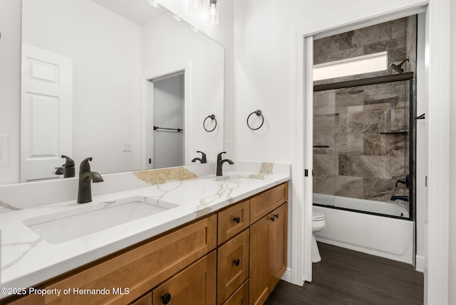 16043 Penn State Rd, Weeki Wachee, FL 34614 - full bathroom with toilet, double vanity, wood finished floors, and washtub / shower combination