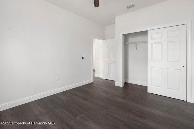 16043 Penn State Rd, Weeki Wachee, FL 34614 - unfurnished bedroom featuring dark wood-style floors, baseboards, a closet, and a ceiling fan