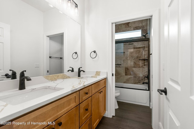 16043 Penn State Rd, Weeki Wachee, FL 34614 - bathroom with toilet, double vanity, wood finished floors, and tub / shower combination