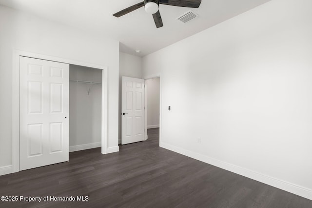 16043 Penn State Rd, Weeki Wachee, FL 34614 - unfurnished bedroom with dark wood-style flooring, baseboards, a closet, and ceiling fan