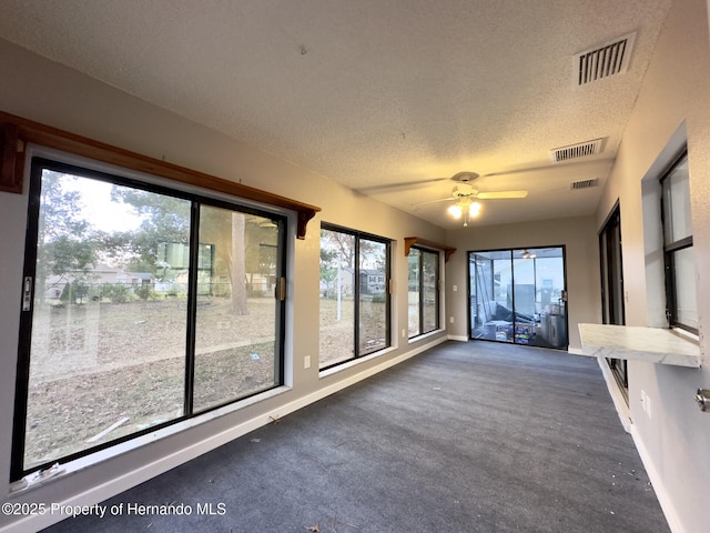 2253 Estill Ave, Spring Hill, FL 34609 - unfurnished sunroom with a textured ceiling, a ceiling fan, healthy amount of natural light, baseboards, and carpet floors
