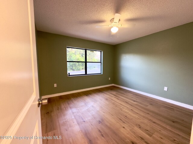 2253 Estill Ave, Spring Hill, FL 34609 - unfurnished room featuring wood finished floors, ceiling fan, a textured ceiling, and baseboards