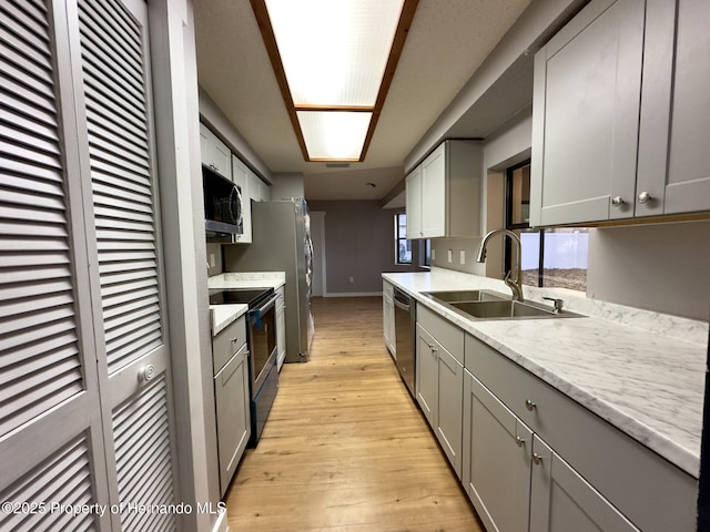 2253 Estill Ave, Spring Hill, FL 34609 - kitchen featuring a sink, appliances with stainless steel finishes, gray cabinets, light wood-style floors, and baseboards