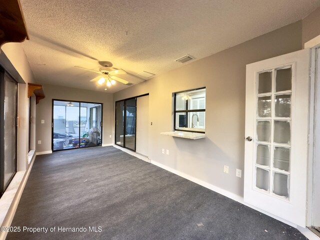 2253 Estill Ave, Spring Hill, FL 34609 - empty room with a textured ceiling, ceiling fan, baseboards, and carpet flooring