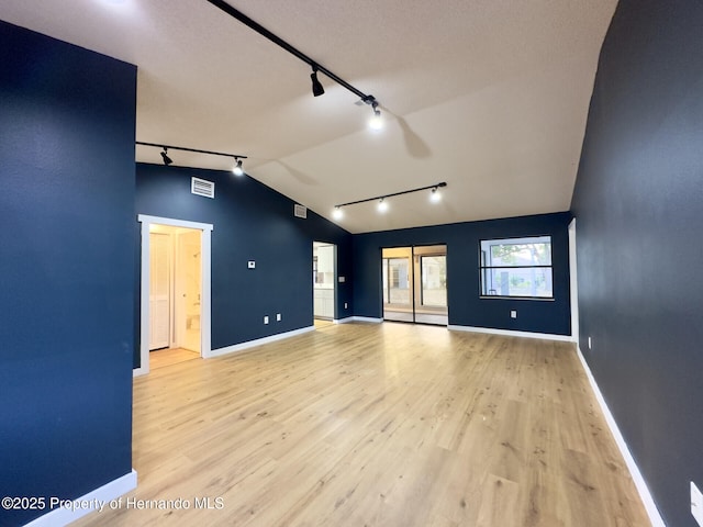 2253 Estill Ave, Spring Hill, FL 34609 - empty room featuring rail lighting, vaulted ceiling, baseboards, and light wood-style floors