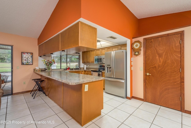 18216 Monteverde Dr, Shady Hills, FL 34610 - kitchen with stainless steel appliances, high vaulted ceiling, light tile patterned flooring, visible vents, and a peninsula