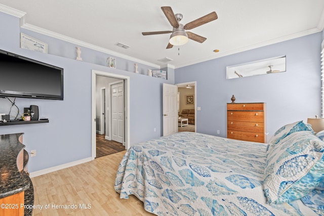 bedroom featuring light wood-style floors, visible vents, crown molding, and a ceiling fan