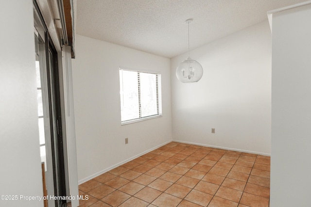 unfurnished room with baseboards and a textured ceiling