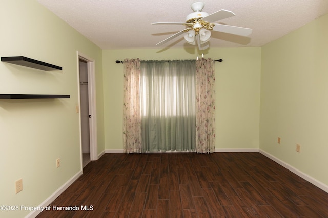 unfurnished bedroom with a textured ceiling, wood finished floors, and baseboards