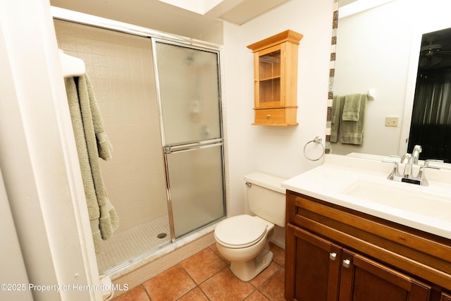 full bath with toilet, a stall shower, vanity, and tile patterned floors