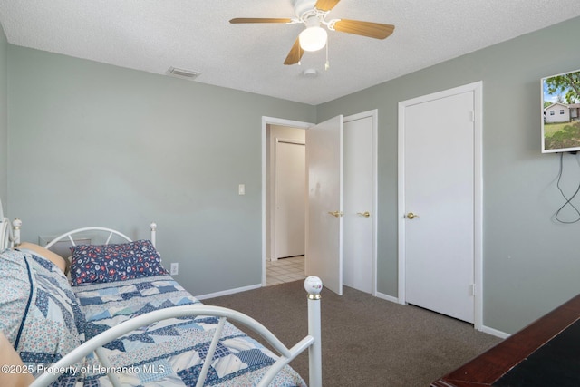 9414 Northcliffe Blvd, Spring Hill, FL 34606 - carpeted bedroom with baseboards, a textured ceiling, visible vents, multiple closets, and ceiling fan